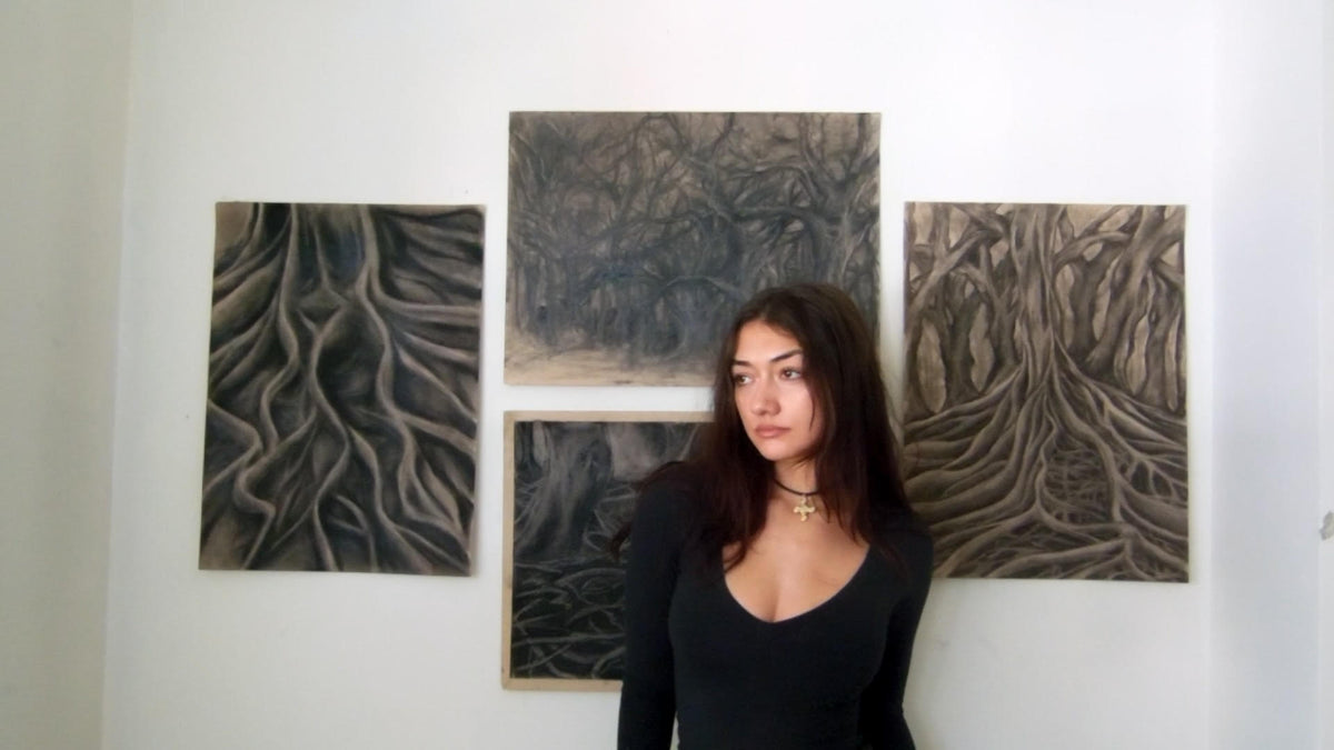 Marissa Lazaridis in the studio in front of four charcoal drawings from Don't Run